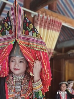 Trang phục truyền thống của cô dâu người Dao đỏ ấn tượng với chiếc "sừng" trên đầu. Ảnh: Tuấn Anh-TTXVN