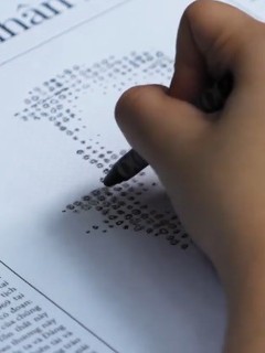 Bạn đọc có thể dùng bút màu tô vào những hình tròn in trên trang báo để vẽ lên chân dung Chủ tịch Hồ Chí Minh. Ảnh: bnews.vn