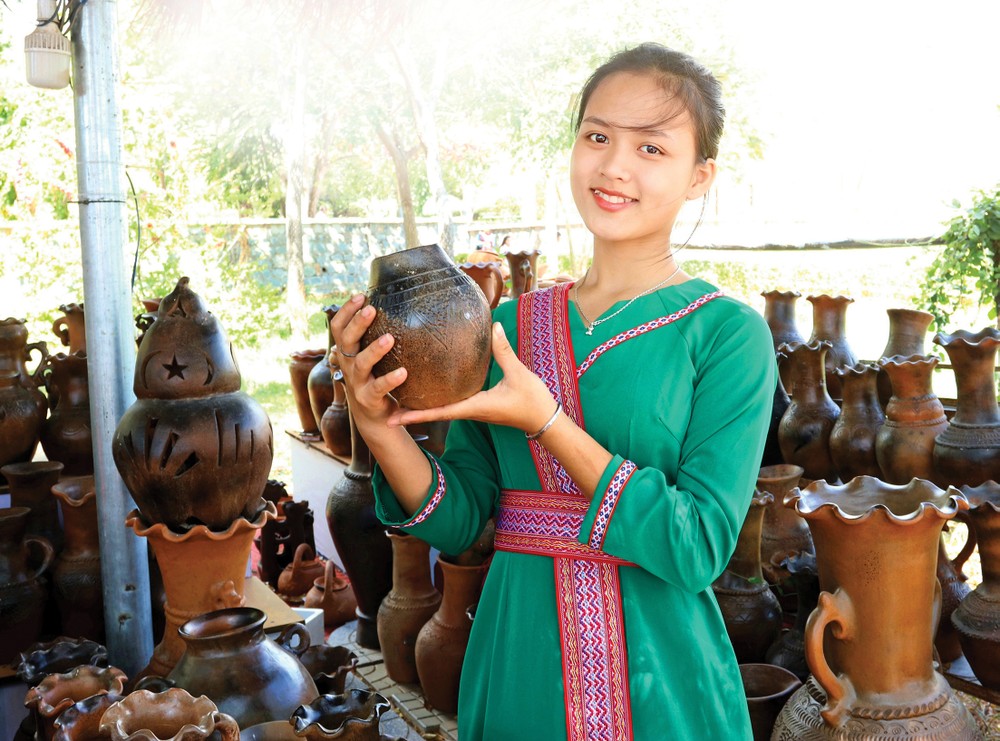 占族少女在潘朗 - 塔占市某处旅游景点介绍宝竹陶瓷产品