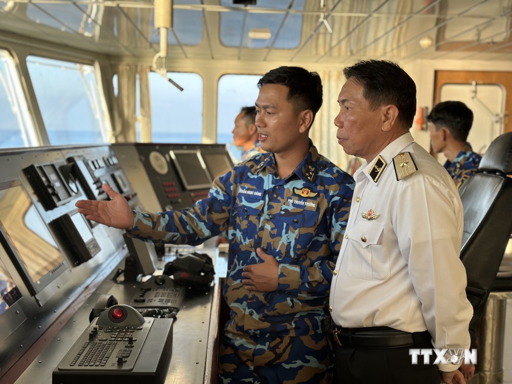 Phó Thuyền trưởng Tàu 571 Trần Ngọc Sáng báo cáo với Chuẩn Đô đốc Phạm Văn Hùng về hải trình và các công tác khi thực hiện nhiệm vụ trên biển. Ảnh: Thùy Giang - TTXVN