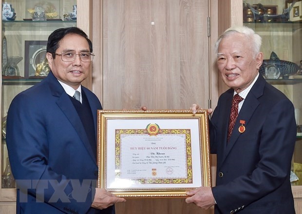 政府总理范明政向原政府副总理武宽授予60年党龄纪念章