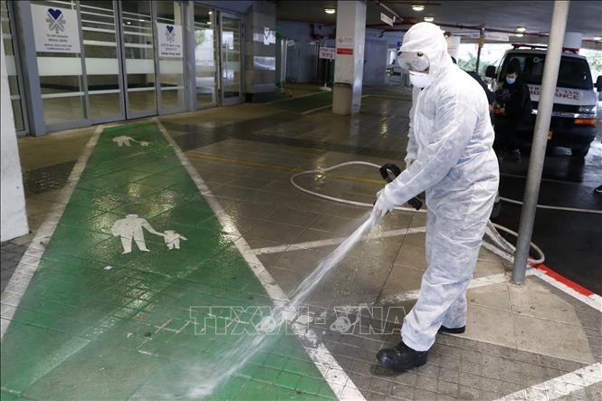 Công nhân phun khử trùng tại bãi đỗ xe của một cơ sở y tế ở thành phố Tel Aviv, Israel nhằm ngăn chặn sự lây lan của dịch COVID-19 ngày 20/3/2020. Ảnh: AFP/TTXVN