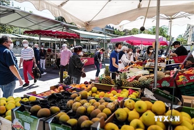 Người dân chọn mua rau củ quả tại chợ ở Strasbourg, Pháp, ngày 13/5/2020. Ảnh: AFP/TTXVN