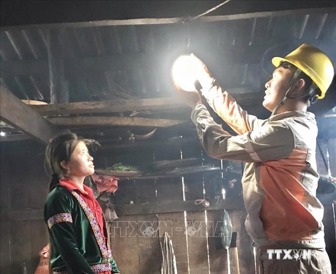 Công nhân Công ty Điện lực Lai Châu thay bóng đèn miễn phí cho người dân. Ảnh: Nguyễn Oanh - TTXVN