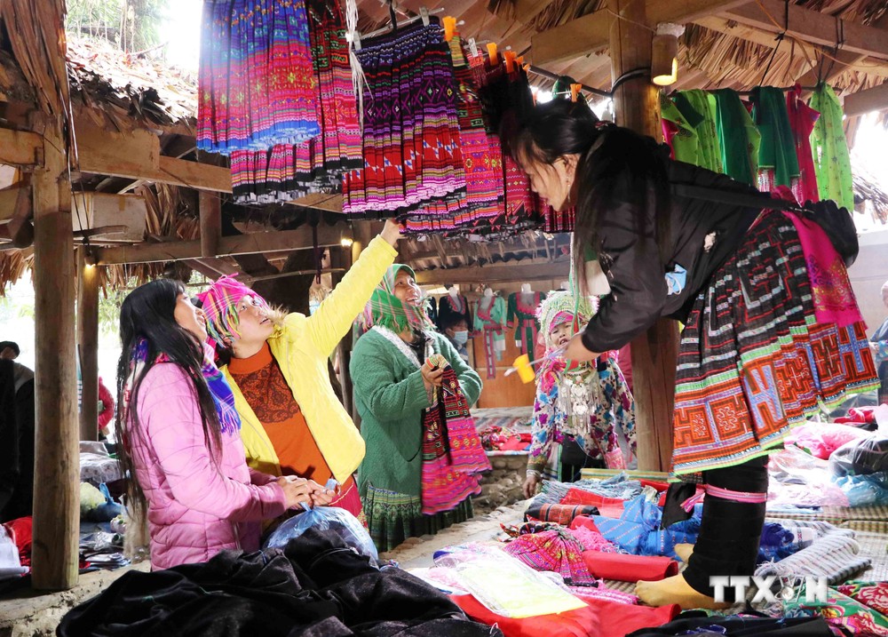 Những phụ nữ Mông bên gian hàng trang phục truyền thống tại chợ phiên Sin Suối Hồ, huyện Phong Thổ (Lai Châu). Ảnh: Nguyễn Oanh - TTXVN
