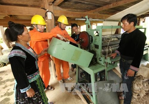 Công nhân Công ty Điện lực Lai Châu (Tổng công ty Điện lực miền Bắc) hướng dẫn bà con dân tộc sử dụng điện an toàn trong sản xuất. Ảnh: Ngọc Hà/TTXVN
