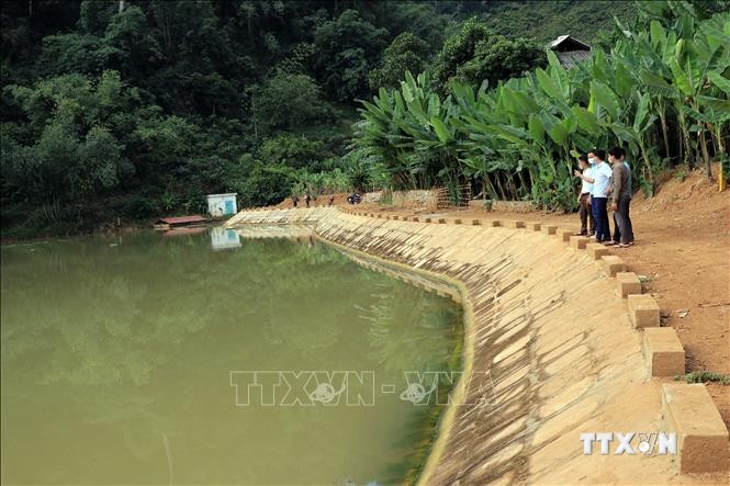 Cán bộ thủy lợi kiểm tra hiện trạng công trình hồ chứa nước Nong La, xã Chiềng La, huyện Thuận Châu, tỉnh Sơn La. Ảnh: Hữu Quyết - TTXVN