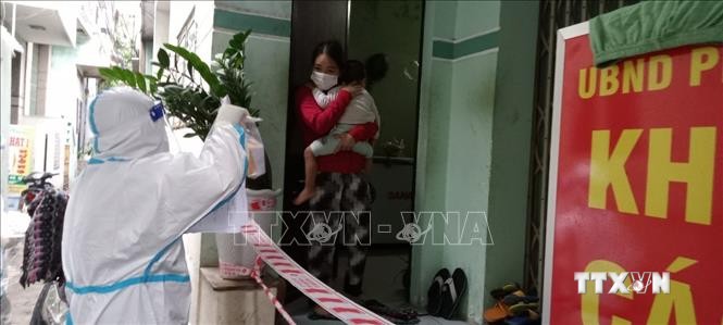 Nhân viện Trạm y tế lưu động phường Hải Cảng (TP Quy Nhơn) đến thăm khám cho bệnh nhân F0 đang điều trị tại nhà. Ảnh:TTXVN