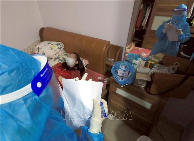 Nhân viên y tế đến kiểm tra sức khỏe và phát thuốc cho trường hợp F0 đang điều trị tại nhà tại Xóm 2, xã Tam Hiệp, huyện Thanh Trì. Ảnh: Tuấn Anh - TTXVN