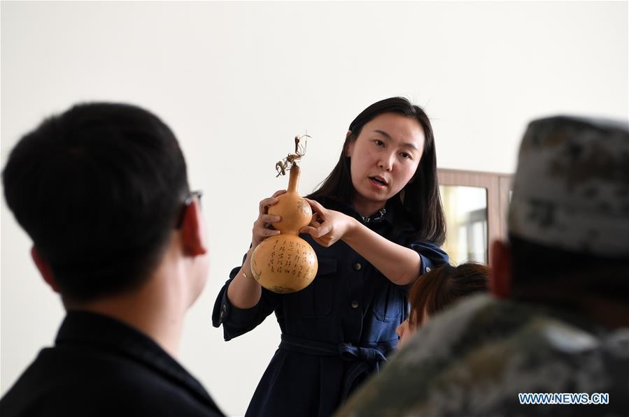 Cô Ruan Xiyue hướng dẫn sinh viên trường Cao đẳng Kỹ thuật Nghề Lan Châu (Lan Châu, Cam Túc, Trung Quốc) về nghệ thuật điêu khắc bầu hồ lô. Ảnh: news.cn