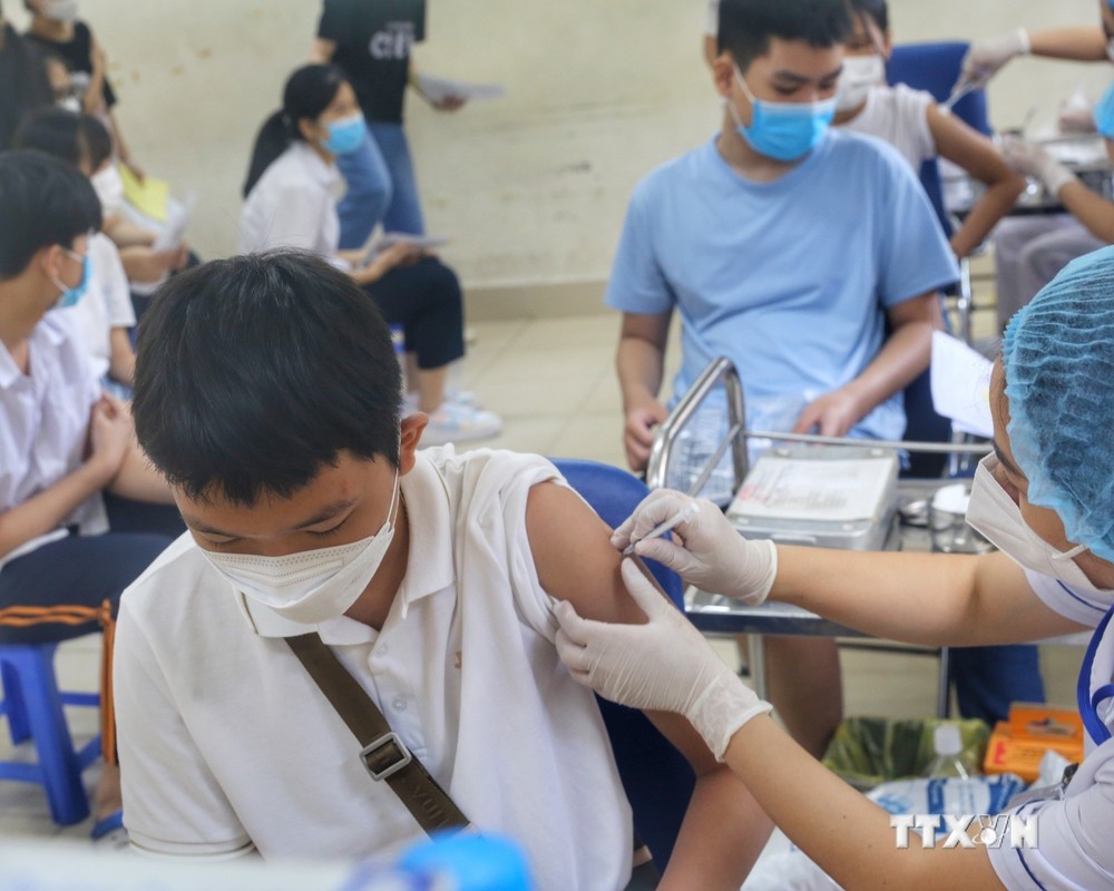 Nhân viên y tế phường Minh Khai (Hà Nội) tiêm mũi nhắc lại cho các em học sinh trường THCS Hà Huy Tập. Ảnh: Tuấn Đức - TTXVN