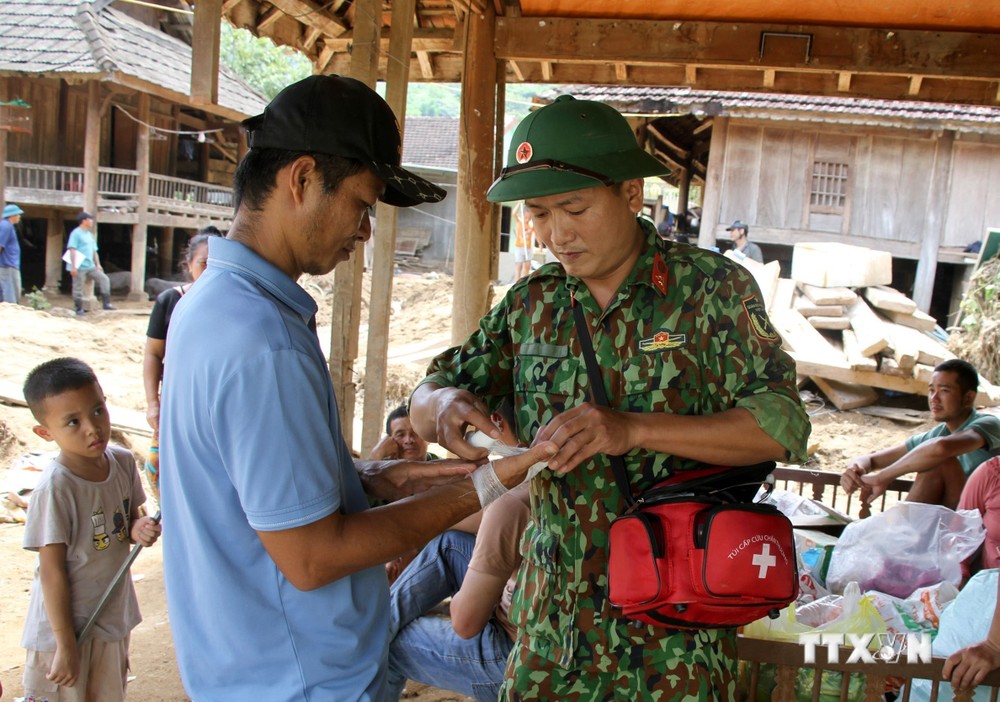Nhân viên quân y, Bộ chỉ huy Quân sự tỉnh Nghệ An thăm khám, cấp phát thuốc cho nhân dân vùng lũ ở huyện Kỳ Sơn. Ảnh: Văn Tý-TTXVN