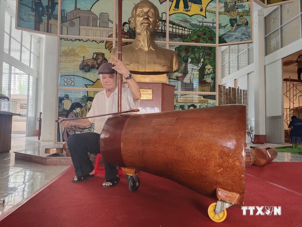 Nghệ nhân Võ Văn Bá sử dụng nhạc cụ đờn cò làm từ gốc dừa lớn nhất Việt Nam. Ảnh: Huỳnh Phúc Hậu - TTXVN
