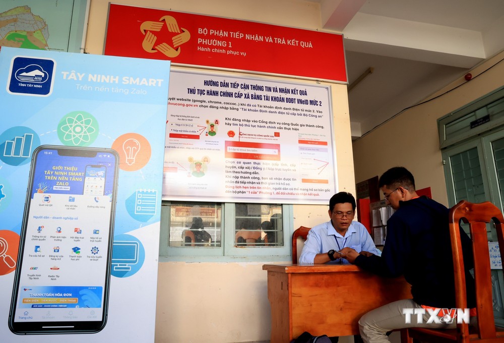 Cán bộ UBND Phường 1 (thành phố Tây Ninh, tỉnh Tây Ninh) hướng dẫn người dân sử dụng tài khoản dịch vụ công quốc gia. Ảnh: Hồng Đạt - TTXVN