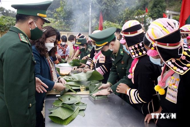 Bộ đội Biên phòng cùng với bà con nhân dân xã Huổi Luông, huyện Phong Thổ (Lai Châu) gói bánh chưng xanh tặng cho hộ nghèo. Ảnh: Đinh Thùy-TTXVN