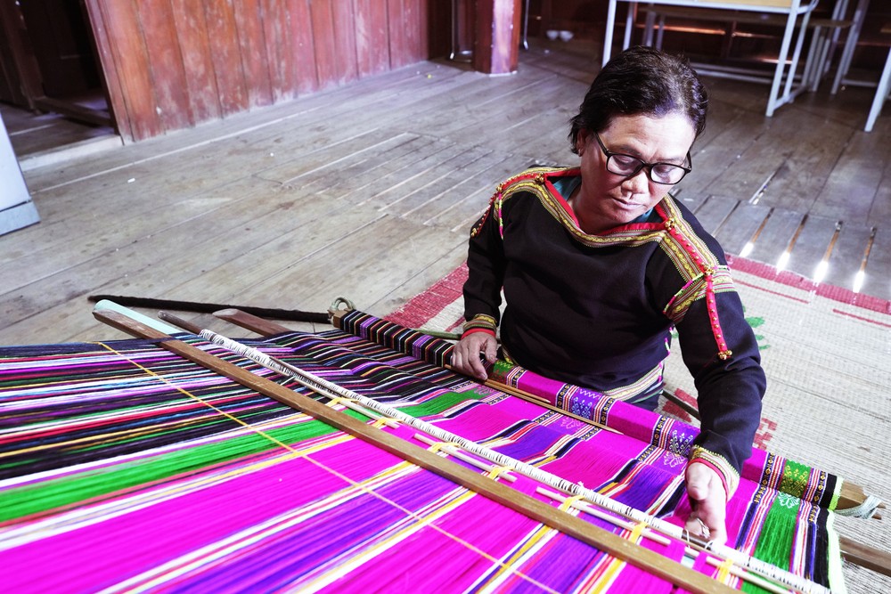Gắn bó với khung cửi gần 50 năm, những khi rảnh rỗi, bà H'Blong Knul lại ngồi dệt để giữ nghề truyền thống. Ảnh: Ngọc Đức 