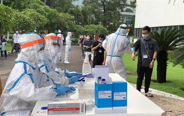 Các y bác sỹ Trung tâm kiểm soát bệnh tật Tp Hồ Chí Minh và Quận 7 thực hiện xét nghiệm sàng lọc COVID-19 ngẫu nhiên cho công nhân ở Khu chế xuất Tân Thuận. Ảnh: Thanh Vũ/TTXVN