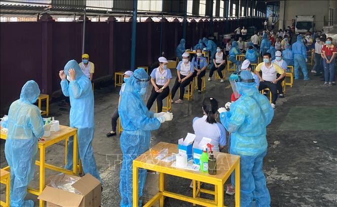 Các y bác sỹ Trung tâm kiểm soát bệnh tật TP Hồ Chí Minh và Quận 7 thực hiện xét nghiệm sàng lọc COVID-19 ngẫu nhiên cho công nhân Công ty TNHH Solen Việt Nam ở Khu chế xuất Tân Thuận ngày 3/6. (Ảnh minh họa)