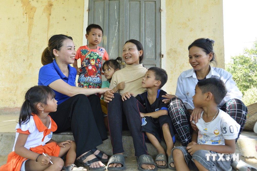 Cô giáo Mai Thị Lâm tuyên truyền, vận động phụ huynh và bà con người dân tộc Hrê cho con đi học. Ảnh: Minh Đức - TTXVN