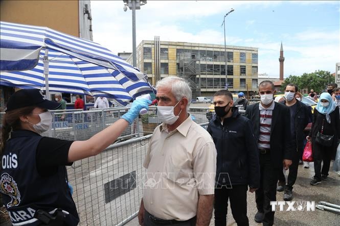 Cảnh sát kiểm tra thân nhiệt của người dân tại lối vào trung tâm thương mại ở Ankara, Thổ Nhĩ Kỳ ngày 22/5/2020 trong bối cảnh dịch COVID-19 lan rộng. Ảnh: THX - TTXVN