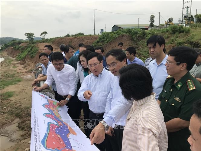 Phó Thủ tướng Phạm Bình Minh nghe lãnh đạo tỉnh Lào Cai báo cáo về kế hoạch và phương án xây cầu biên giới tại khu vực xã Bản Vược, huyện Bát Xát. Ảnh: Hồng Ninh-TTXVN