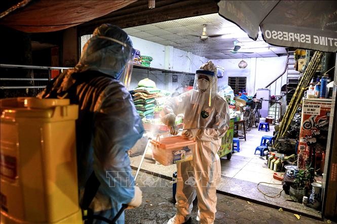 Lực lượng y tế quận Tây Hồ tiến hành phun khử khuẩn các hộ lân cận ngõ 466 Hoàng Hoa Thám. Ảnh: Thành Đạt – TTXVN