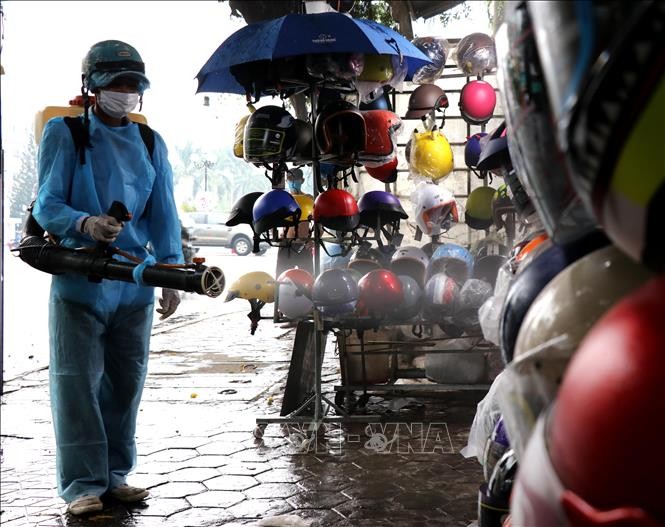 Nhân viên y tế phun thuốc tiêu độc, khử trùng tại tổ 3, phường Lê Hồng Phong. Ảnh: Lê Ngọc Phước- TTXVN
