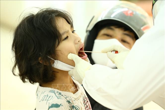 Nhân viên y tế lấy mẫu dịch hầu họng để xét nghiệm bằng phương pháp RT-PCR cho người dân phường Đội Cấn (Ba Đình). Ảnh: Minh Quyết - TTXVN
