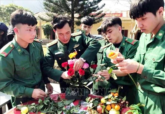 Các cán bộ chiến sỹ Đồn Biên phòng Cà Xèng cắm hoa đón Tết. Ảnh: TTXVN phát