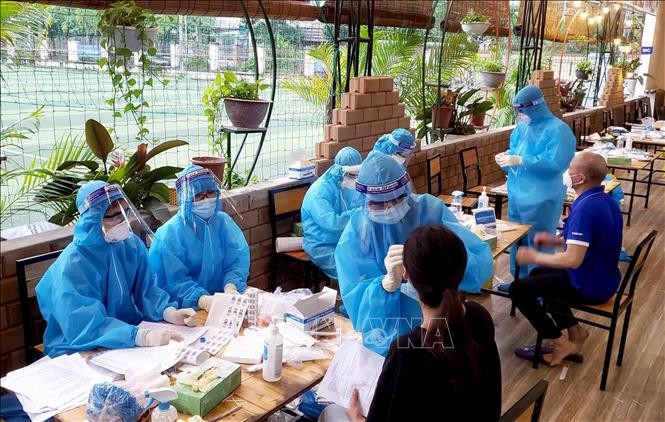  Nhân viên y tế lấy mẫu dịch hầu họng cho người dân ở Khu đô thị Đồng Sơn, thành phố Phúc Yên. Ảnh: Hoàng Hùng - TTXVN