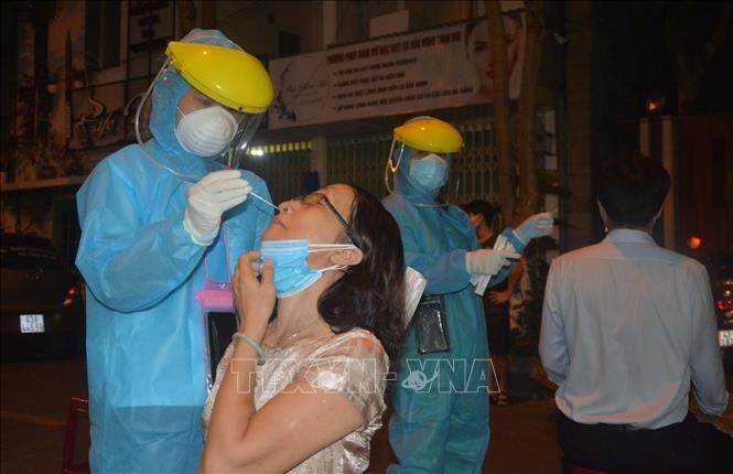 Nhân viên y tế quận Hải Châu khẩn trương lấy mẫu xét nghiệm người dân ngay trong đêm. Ảnh: Văn Dũng - TTXVN