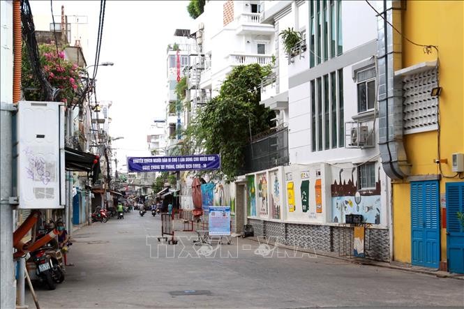 Chính quyền địa phương cảnh báo tăng cường phòng, chống COVID-19 tại chợ tự phát trên đường Cao Thắng, quận Phú Nhuận dù . Ảnh: Thanh Vũ - TTXVN