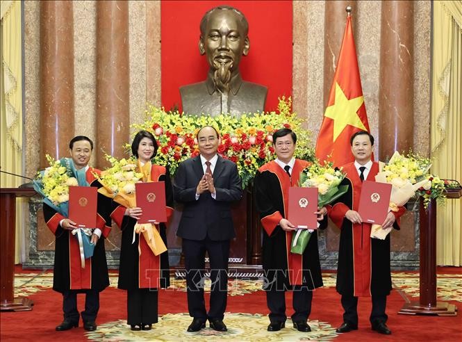 Chủ tịch nước Nguyễn Xuân Phúc trao quyết định và tặng hoa chúc mừng 4 Thẩm phán Tòa án nhân dân tối cao. Ảnh: Thống Nhất – TTXVN