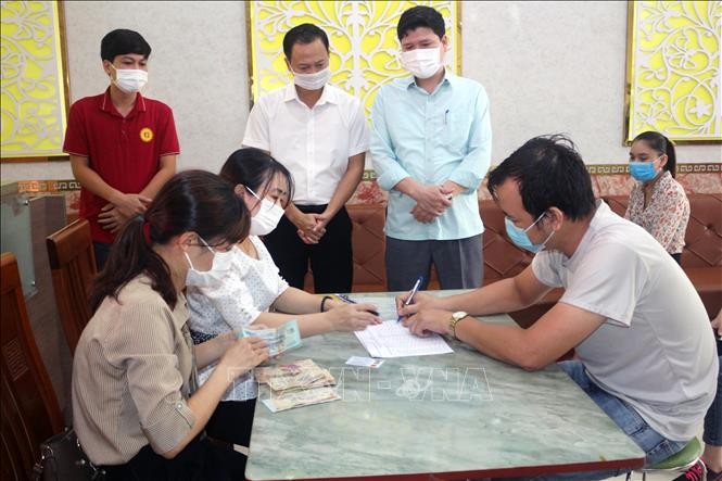 Các lao động tạm hoãn thực hiện hợp đồng lao động nghỉ việc không lương tại huyện Lý Nhân (Hà Nam) được nhận hỗ trợ từ nguồn kinh phí 26.000 tỉ đồng. Ảnh: Đại Nghĩa – TTXVN