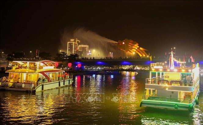 Du khách đến Đà Nẵng được tặng vé miễn phí thưởng ngoạn sông Hàn về đêm. Ảnh: TTXVN