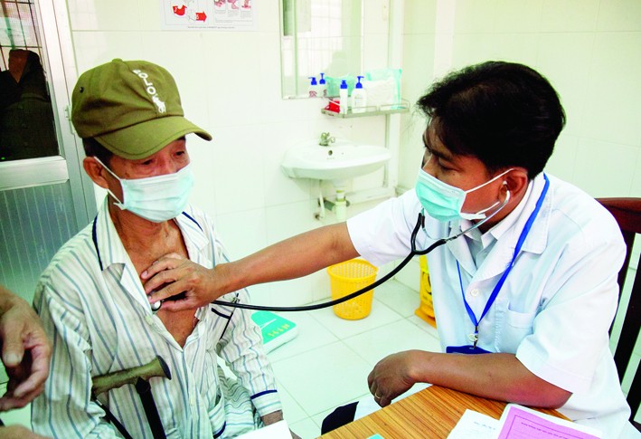 Bác sĩ Danh Ngọc Châu khám bệnh cho người dân có hoàn cảnh khó khăn tại phòng khám Trung tâm Y tế huyện Châu Thành. Ảnh: Hồng Đạt