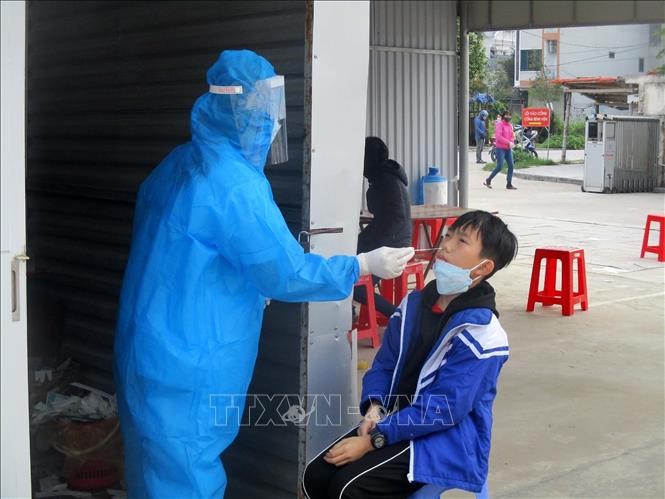 Nhân viên y tế tỉnh Thanh Hóa lấy mẫu xét nghiệm COVID-19 cho học sinh. Ảnh: Nguyễn Nam-TTXVN