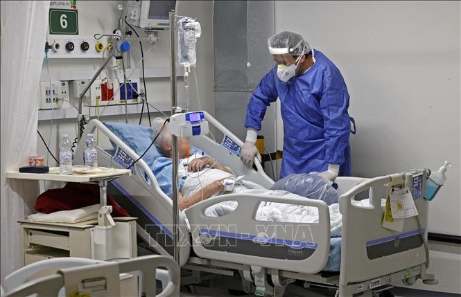 Nhân viên y tế điều trị cho bệnh nhân COVID-19 tại bệnh viện ở Petah Tikva, Israel, ngày 1/2/2022. Ảnh: AFP/ TTXVN