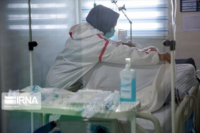 Nhân viên y tế điều trị cho bệnh nhân COVID-19 tại bệnh viện ở Iran. Ảnh: IRNA/ TTXVN