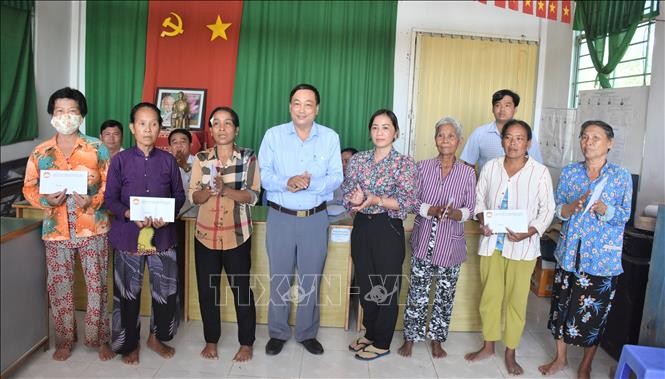 Phó Chủ tịch Ủy ban Mặt trận Tổ quốc Việt Nam tỉnh Sóc Trăng Lâm Dũng Liêm trao tiền hỗ trợ đến các hộ dân bị ảnh hưởng. Ảnh: Danh Chanh Đa - TTXVN