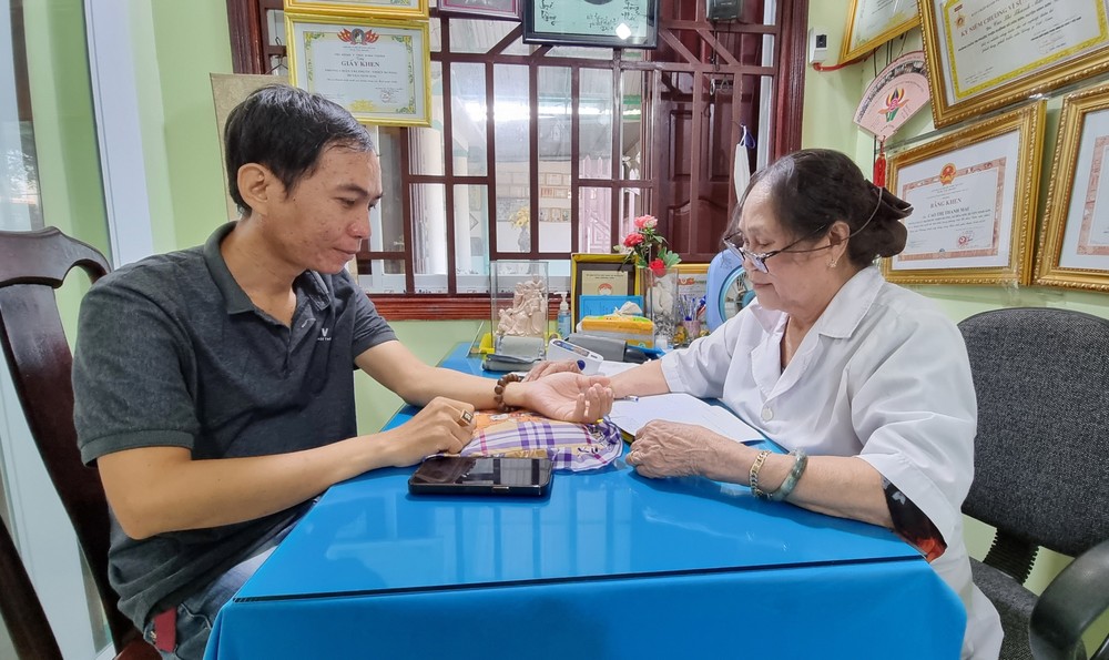 Cựu chiến binh, lương y Cao Thị Thanh Mai khám, chữa bệnh cho bệnh nhân. Ảnh: Nguyễn Thành – TTXVN