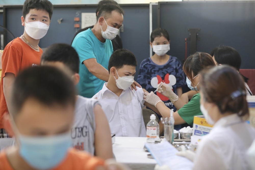 Nhân viên y tế quận Đống Đa tiêm vaccine cho học sinh tại điểm tiêm trường THCS Bế Văn Đàn (Hà Nội). Ảnh: Minh Quyết - TTXVN