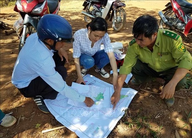Cán bộ Quỹ Bảo vệ và Phát triển rừng tỉnh Kon Tum kiểm tra thực tế diện tích rừng giao cho người dân quản lý, bảo vệ. Ảnh: TTXVN phát.
