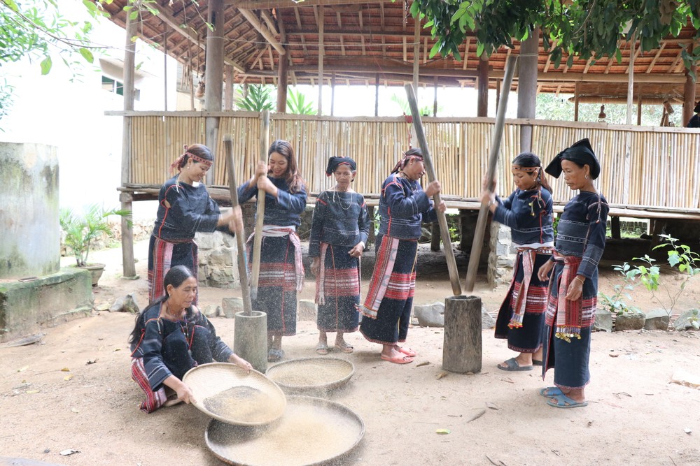 Phụ nữ trong làng K'giang, xã Kong Lơng Khơng, huyện K'bang (Gia Lai) tập trung giã, sàng lựa chọn hạt cào để chuẩn bị làm rượu cần. Ảnh: Hồng Điệp