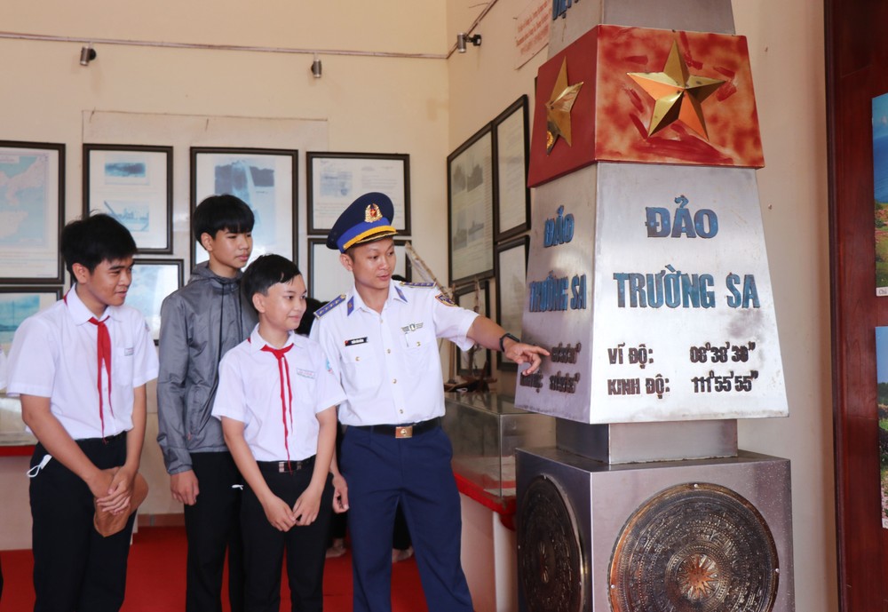 Cán bộ Cảnh sát biển và học sinh tìm hiểu thông tin về hai quần đảo Hoàng Sa, Trường Sa của Việt Nam. Ảnh: Phạm Cường-TTXVN