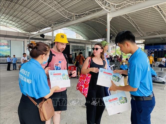 Các du khách nước ngoài rất ủng hộ việc làm của huyện đảo Cô Tô, vui vẻ thay đổi túi nilon sang túi giấy. Ảnh: TTXVN