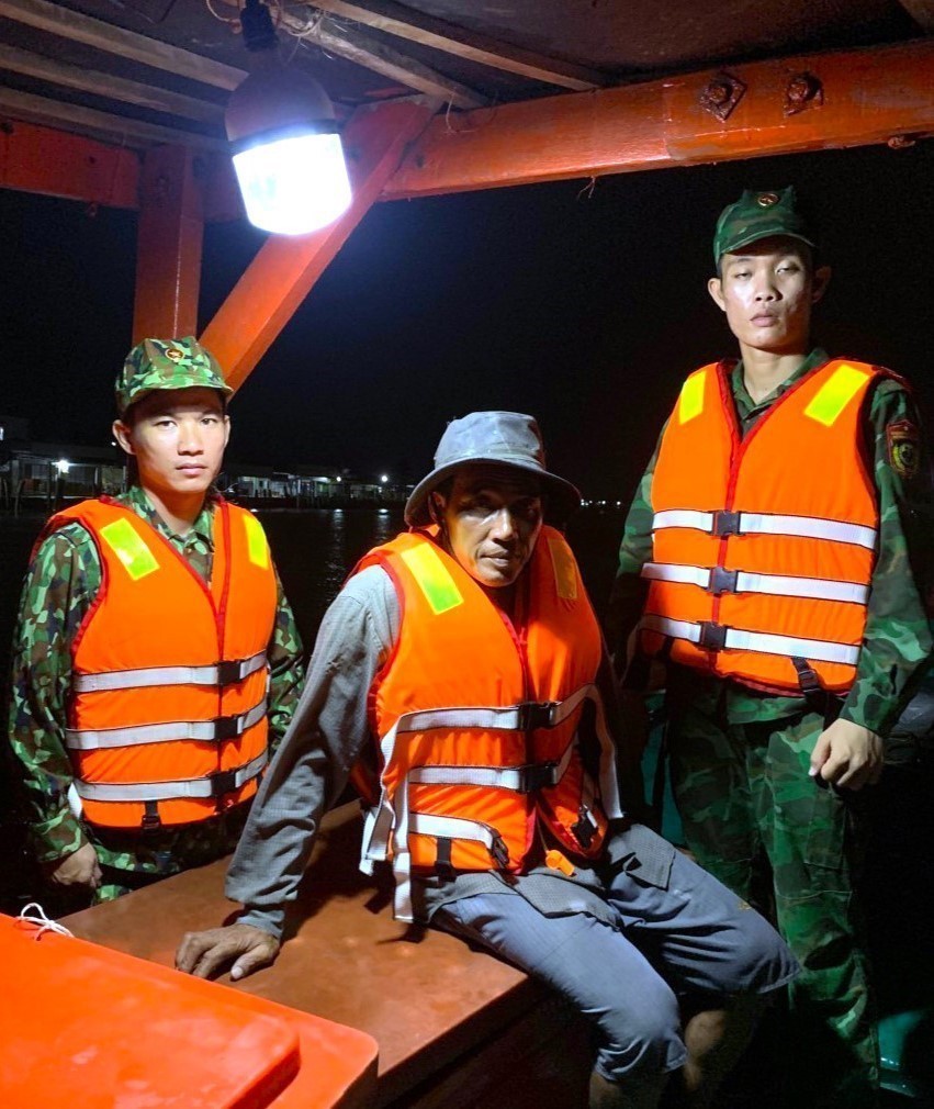 Thuyền viên Trương Văn Nhứt (giữa) vừa được lực lượng Bộ đội Biên phòng Cà Mau cứu vớt đưa lên tàu an toàn. Ảnh: TTXVN phát