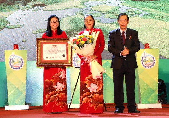 Lãnh đạo Sở Văn hóa, Thể thao và Du lịch Đồng Nai đón nhận bằng Kỷ lục châu Á với món xôi chiên phồng Đồng Nai.Ảnh: nhandan.vn