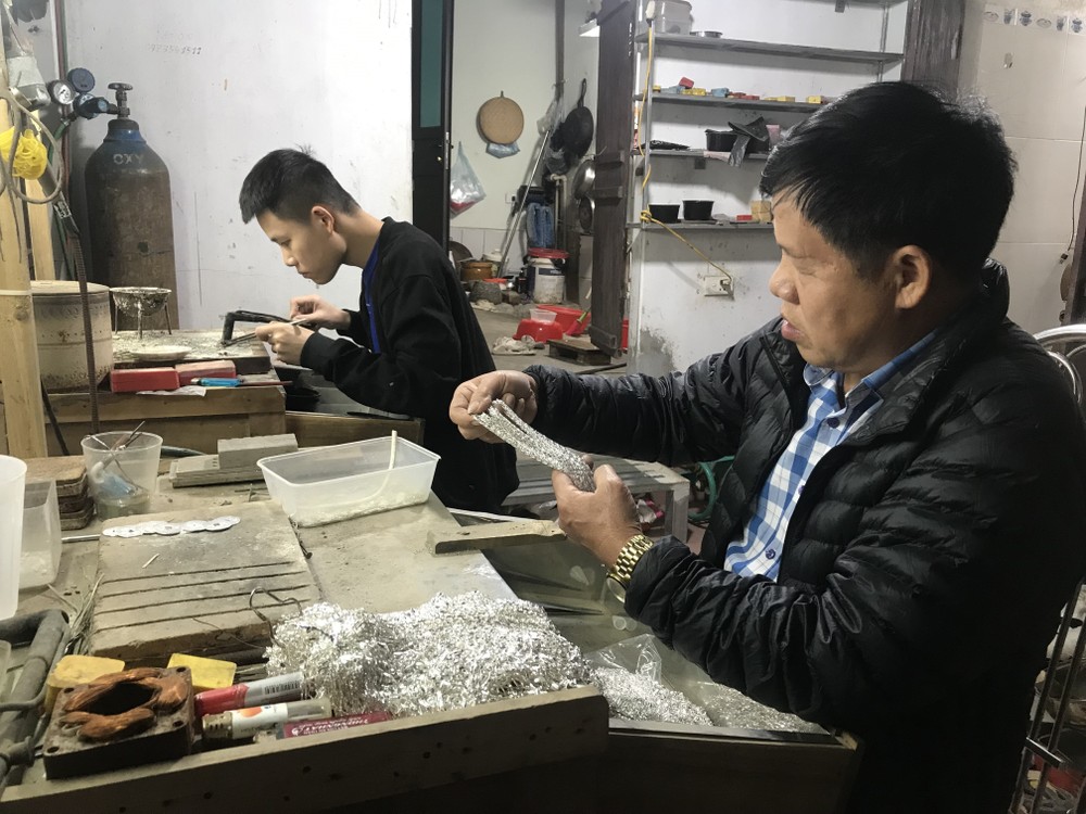 Nghệ nhân Phạm Bình Minh kiểm tra chất lượng dây truyền bạc. Ảnh: Tiến Vĩnh – TTXVN