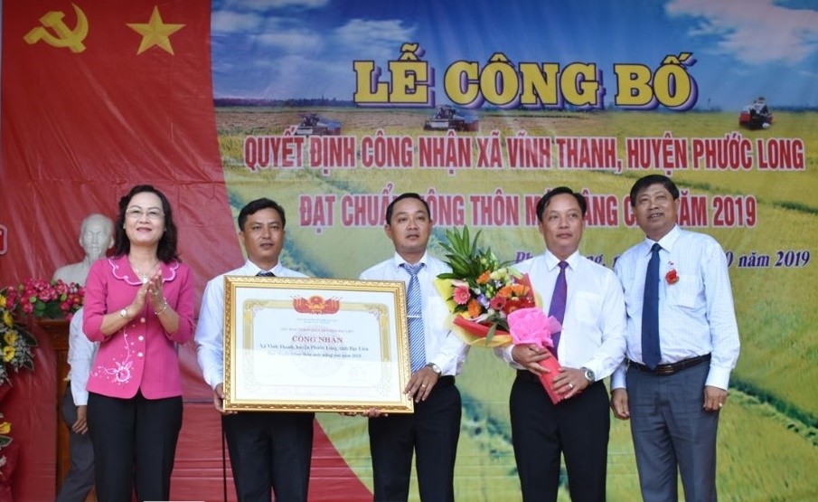 Lãnh đạo Tỉnh ủy, UBND tỉnh Bạc Liêu trao bằng công nhận và tặng hoa chúc mừng xã Vĩnh Thanh đạt chuẩn NTM nâng cao. Ảnh:baobaclieu.vn 